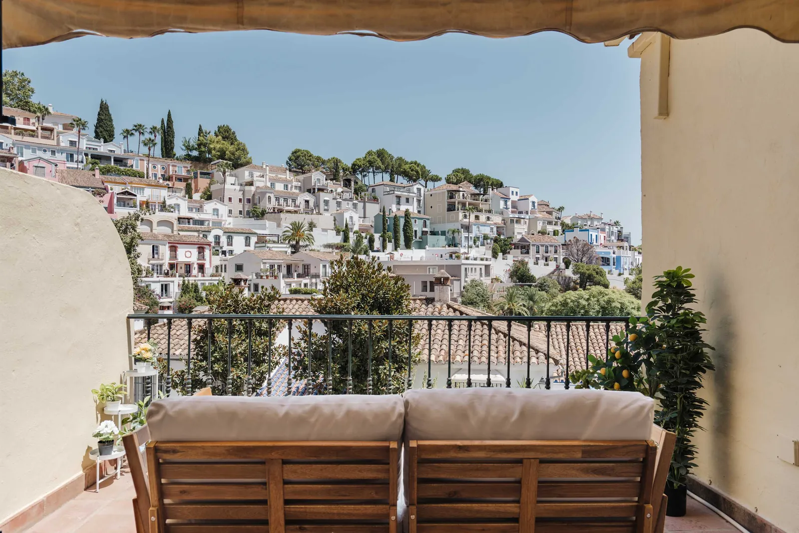 Balcony of Casa Heredia with a wooden sofa, looking across the whitewashed rooftops of La Heredia