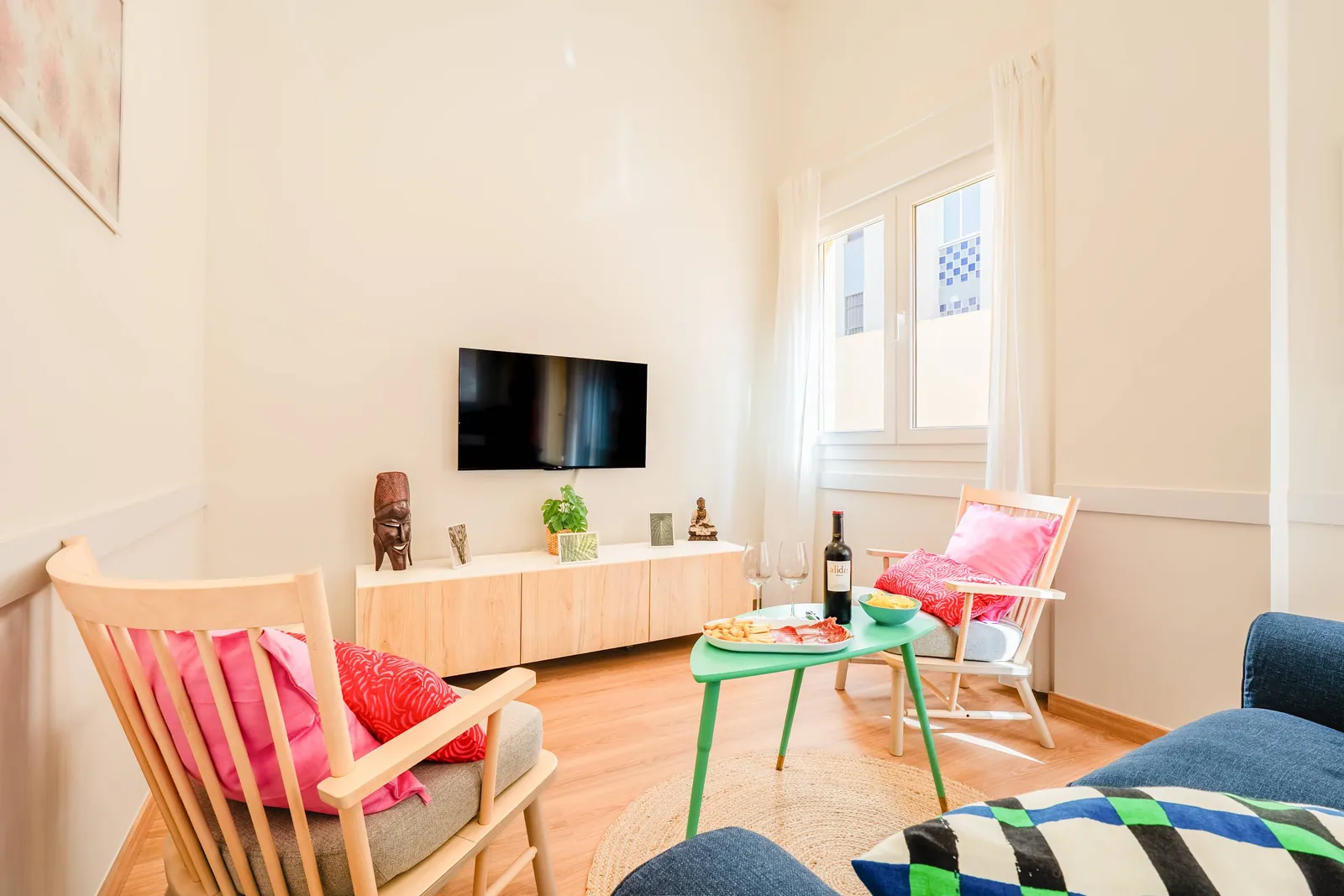 Living room of the first-line beach apartment at Playa Mar, with a television and colourful cushions